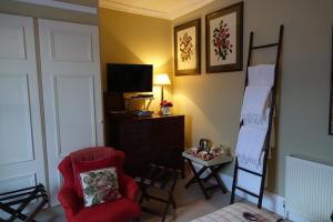 布鲁莱迪Loch Gorm House的客厅配有红色椅子和电视