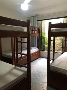 纳塔尔Get Up Hostel的客房设有三张双层床和一扇窗户。