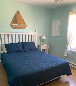 谢尔本维斯波灵韦弗斯小屋假日公园的蓝色卧室,配有一张带蓝色棉被的床