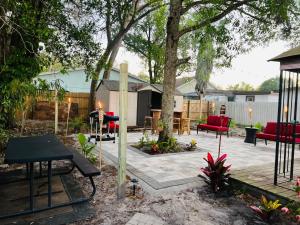 坦帕Tropical Casita in Tampa near airport and Raymond James stadium的一个带红色椅子和树的庭院