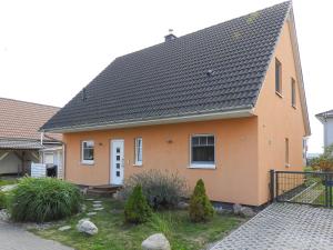 佩讷明德Peenemünde, TOP-Ferienhaus am Seglerhafen的黑色屋顶橙色房子