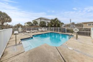 格尔夫海岸GulfShores BeachCondo - Pool - FreeParking - SummerTime! - Little Lagoon的一个带椅子和围栏的游泳池