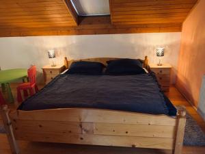 Ober-TurčekChata pod lesom的一间卧室配有一张带2个床头柜的大型木床
