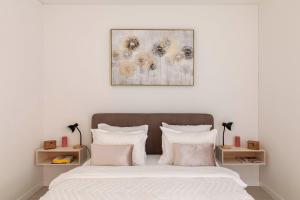 卢加诺Central Superior Suites - Free Parking的一间卧室配有带白色床单和粉红色枕头的床。