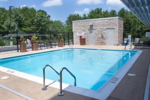 CottondaleHoliday Inn Express & Suites - Tuscaloosa East - Cottondale, an IHG Hotel的一座大型游泳池,其建筑背景为: