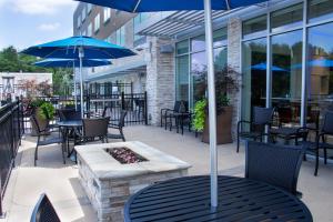 CottondaleHoliday Inn Express & Suites - Tuscaloosa East - Cottondale, an IHG Hotel的一个带桌椅和遮阳伞的庭院
