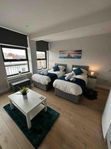 北安普敦King Bed Studio Apartment in Central Northampton的客厅配有两张床和茶几