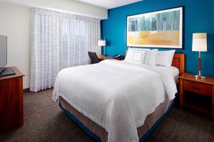 地球城圣路易斯机场/地球城原住客栈的酒店客房设有一张大床和蓝色的墙壁。