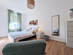 莱比锡HappySide - Sm00th - Landhaustil - WLAN - Nespresso的一间卧室配有一张床、镜子和一张沙发
