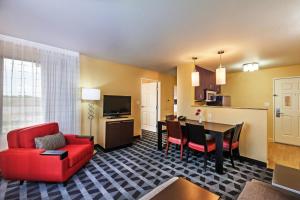 布罗肯阿罗万豪塔尔萨断箭广场套房酒店的一间带红色沙发的客厅和一间厨房