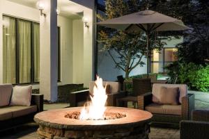 布鲁艾施辛辛那提兰辉庭院酒店的一个带椅子和遮阳伞的庭院内的火坑