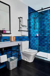 明尼阿波利斯明尼阿波利斯上城区慕奇夕酒店的浴室设有卫生间、水槽和蓝色瓷砖。