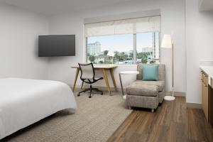 杰克逊维尔海滩Element Jacksonville Beach的酒店客房,配有一张床、一张桌子和椅子