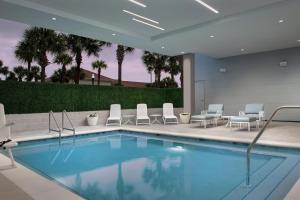 杰克逊维尔海滩Element Jacksonville Beach的一座带椅子的酒店游泳池