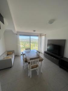 维拉卡洛斯帕兹Duplex en plena montaña的客厅配有桌子、沙发和电视