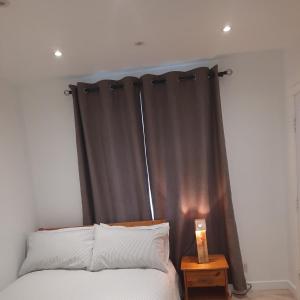 伦敦Dannifar Guest House的一间卧室配有一张带黑色窗帘的床