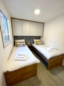 德拉格FJAKA luxury mobile home - Oaza Mira Camping Croatia的小客房内的两张床和两条毛巾