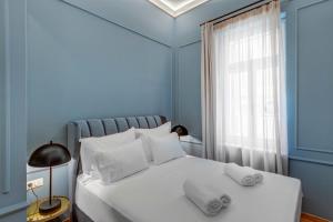 埃尔莫波利斯Amare Boutique Suites的蓝色卧室配有白色床和2个枕头