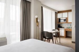 皇后区TownePlace Suites by Marriott New York Long Island City的酒店客房设有一张床铺、一张桌子和一间厨房。