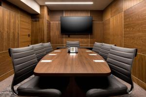 皇后区TownePlace Suites by Marriott New York Long Island City的一间会议室,配有木桌和一台平面电视