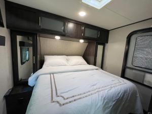 泰特斯维尔Lake front RV experience close to port Canaveral and Kennedy space center的卧室配有一张位于走廊的床铺