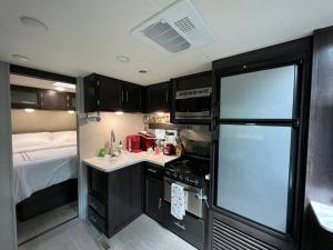 泰特斯维尔Lake front RV experience close to port Canaveral and Kennedy space center的一间带冰箱和床的小厨房