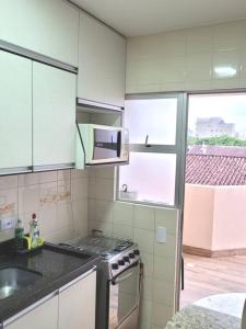 瓜拉图巴Apartamento Brejatuba Beira Mar的厨房配有炉灶和微波炉。