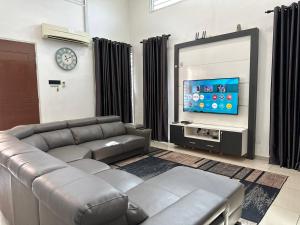 马六甲Bandar Melaka Family Bungalow Private Pool BBQ WiFi Netflix的带沙发和平面电视的客厅