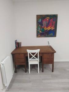 加尔达考Precioso apartamento en Bilbao.的一张带白色椅子和绘画的木桌