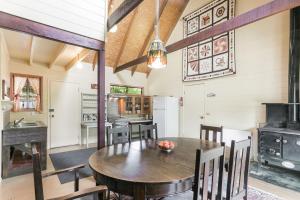 温特沃斯瀑布阿卡迪亚小屋的厨房以及带木桌和椅子的用餐室。