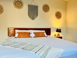 奇琴伊察CASA VICTORIA的卧室配有带橙色枕头的白色床