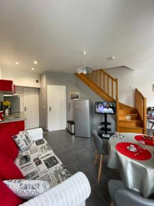 贝叶La Citadine的一间带红色沙发的客厅和一间厨房