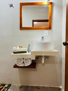 奇琴伊察CASA VICTORIA的浴室配有盥洗盆、镜子和毛巾