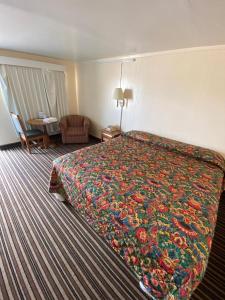 塔尔萨Western inn的酒店客房设有一张大床和色彩缤纷的毯子