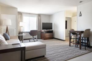 布雷亚Residence Inn by Marriott Anaheim Brea的带沙发、书桌和电视的客厅