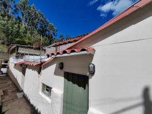 库斯科Centro Cusco Inti的白色房子的一侧有一扇绿门