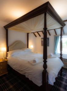 赫尔姆斯利Riccal Dale Cottage的卧室配有带白色床单的天蓬床