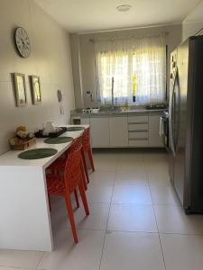 普拉亚多CASA CONDOMÍNIO IBEROSTATE - RESORT IBEROSTAR的厨房配有冰箱和桌椅