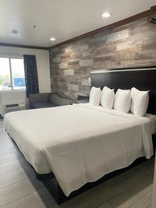 亨廷顿海滩亨廷顿海滩星光酒店的卧室配有一张带白色床单和枕头的大床。