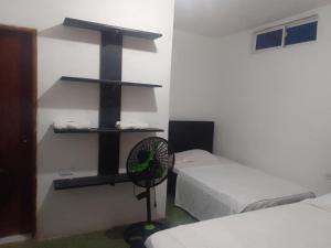 圣贝尔纳多德尔比恩托Tadù Playa Hotel的客房设有两张床和墙上的风扇。