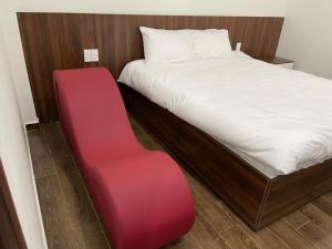 Kiến AnAdal Motel的一张红色长凳,旁边是房间里的床