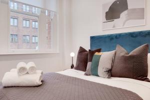 伦敦Number 8 Borough Apartments 2 Bed 2 Bath的卧室配有带枕头的大床和窗户。