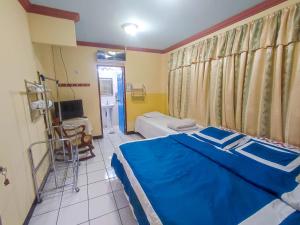 马那瓜Hotel Fuente de Paz Managua的一间卧室配有蓝色的床和电视