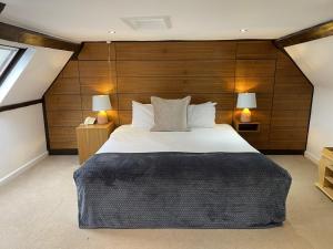 兰达弗里城堡酒店的一间卧室设有一张带木墙的大床