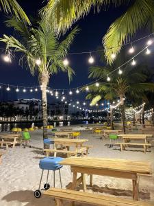 河内VINHOME OCEAN PARK GIA LÂM的海滩上设有野餐桌,晚上种植棕榈树