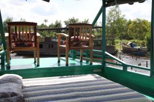 庞卡兰布翁Orangutan Kelotok Houseboat for 6 person的两把椅子和一张船后床