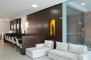 罗萨里奥Hotel Necof的一间带白色沙发的客厅和一间用餐室