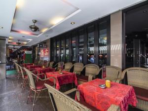 芭堤雅市中心Copa Hotel的餐厅配有桌椅和红色桌布