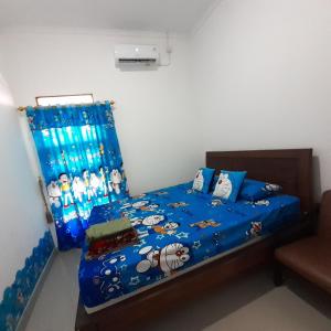 井里汶WIEN HOMESTAY CIREBON - B7 Family Homestay的一间卧室配有一张带蓝色棉被的床