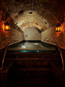巴勒莫PALAZZO SANTAMARINA Luxury Suite & Spa的石洞内的浴缸,带灯光